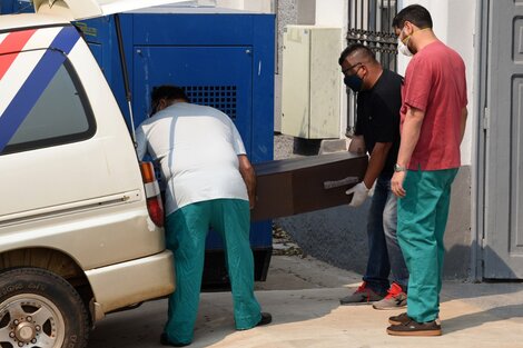 Empleados de la oficina forense cargan el cajón de una de las niñas en la morgue judicial.