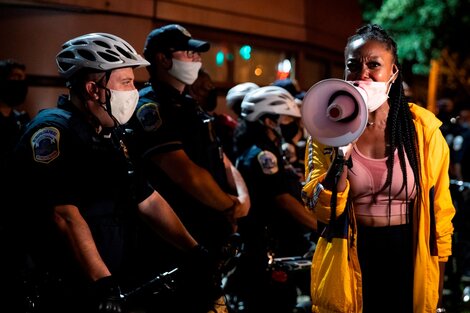 Una manifestante protesta en la cara de una fila de policías en Washington D.C.
