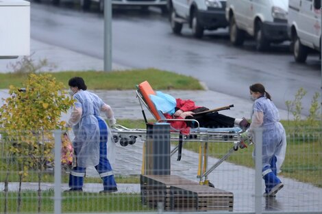 Dos enfermeras ingresan a un paciente al hospital Kommunarka, cercade Moscú, en medio de la pandemia.