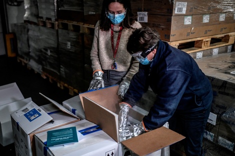 Trabajadores de  salud abren las primeras cajas de vacunas Pfizer en una farmacia mayorista cerca de París