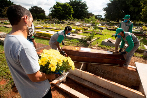 Empleados preparan a víctimas de covid-19 para ser enterrados, en el cementerio de Campo da Esperança, en Brasilia (Brasil). 