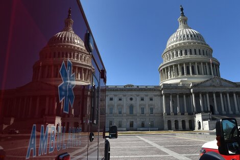 Una ambulancia estacionda frente a un Capitolio desierto. 