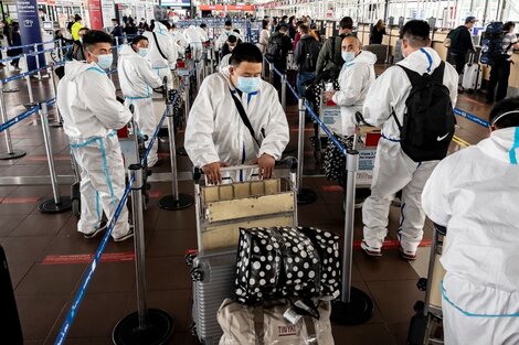 Pasajeros en el aeropuerto de Santiago con ropa de protección. 