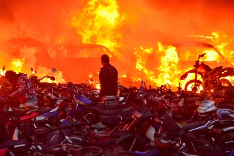  Un hombre camina junto a motocicletas incineradas en Popayán luego de una nueva jornada de protestas.