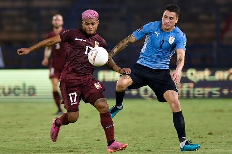 El uruguayo José María Giménez y el venezolano Josef Martínez disputan la pelota.