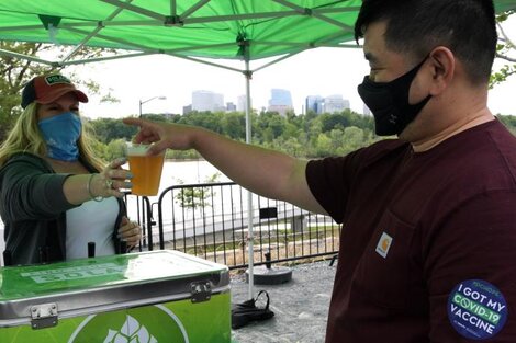 Un hombre vacunado recibe su vaso de cerveza gratis como "premio".