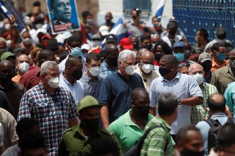 El presidente de Cuba Miguel Díaz-Canel (c) camina acompañado por simpatizantes por una calle del pueblo San Antonio de los Baños (Cuba).