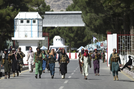 Los talibanes caminan por la puerta de entrada principal del aeropuerto de Kabul.