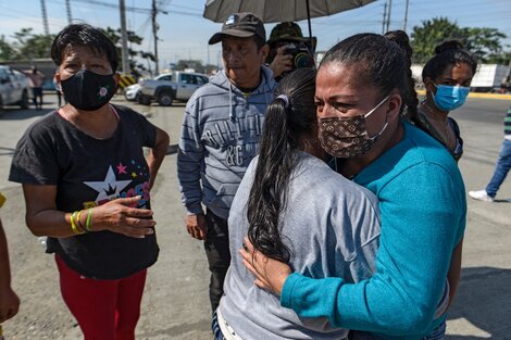 Familiars de detenidos se abrazan después del motín en la entrada a la cárcel de Guayaquil. 