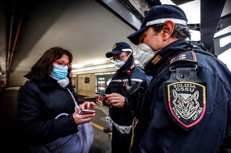 Policías italianos revisan el pase verde de una mujer en el centro de Roma. Foto2: Inspeccion de pases verdes en una para de autobuses en Brescia. (EFE) (Fuente: EFE)