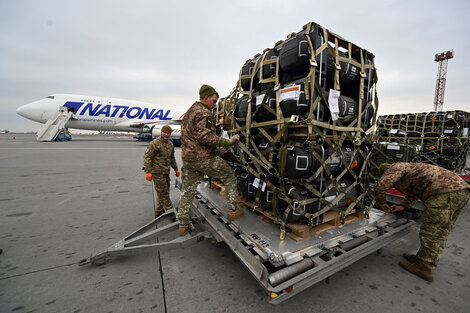 Soldados ucranians desembarcan material bélico estadounidense en el aeropuerto de Kiev.