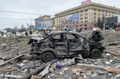 Un auto quemadoenmedio de escombros en la plaza central de Kharkiv, Ucrania.