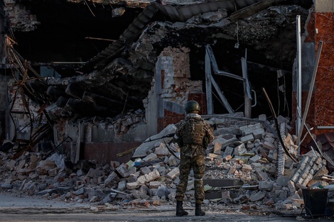 Un soldado ucraniano observa los restos de una tienda en Volnovakha, Ucrania