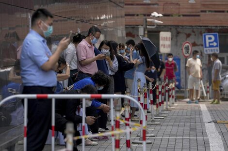 Personas con barbijos hacen fila mientras esperan pruebas masivas de COVID-19 en Beijing el jueves 16 de junio de 2022. (Foto AP/Andy Wong)