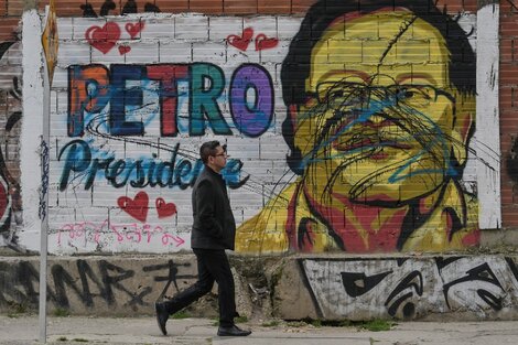 Un hombre camina delante de un mural de Petro en Bogotá, Colombia.