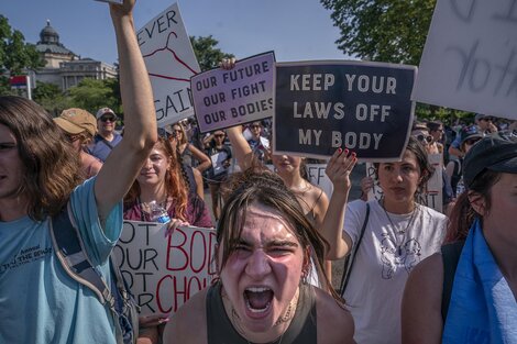 "Saquen sus leyes de nuestros cuerpos", dice uno de los carteles que demandan contra el fallo de la Corte Suprema de los Estados Unidos.