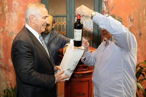 Stanley recibe una botella de vino delante de la estatua de Fontanarrosa.