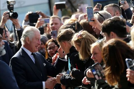 El rey Calos III saludando a las personas que esperan en colas de hasta 14 horas, para entrar en la capilla ardiente a despedirse de la Reina Isabel III. (Foto: AFP)