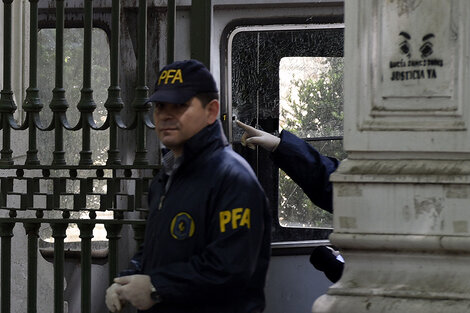 Un agente de la federal señala el orificio de bala en el vidrio de la garita. (Fuente: Andres Macera)