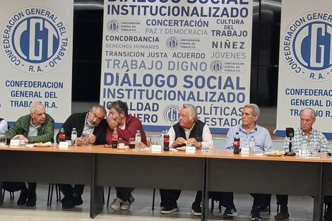 Gerardo Martínez cuchichea con Héctor Daer bajo la atenta mirada de Luis Barrionuevo.