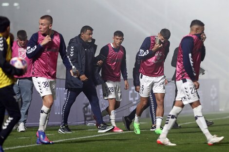 Los jugadores de Gimnasia, retirándose del campo de juego afectados por los gases lacrimógenos (Foto: AFP).