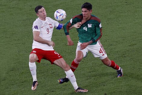 Lewandowski disputa la pelota con Edson Álvarez.