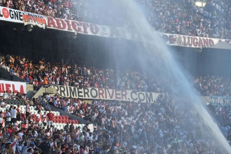 Bomberos tiran agua a las tribunas y plateas del Más Monumental de Nuñez, el domingo durante el partido River-Argentino Jrs. (Foto: Telam).