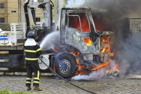 Un bombero intenta controlar el fuego de un vehículo en llamas en Parnamirim. 