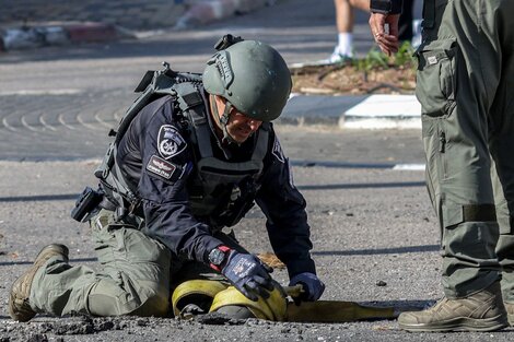 Un soldado israelí inspecciona un cohete interceptado en el pueblo de Sholmi.