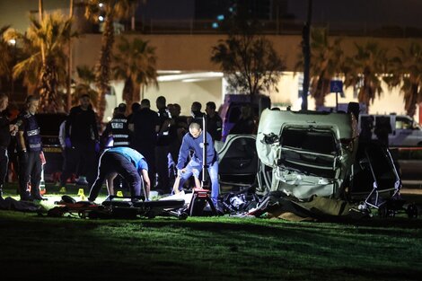 Policías remueven el cadaver de la víctima fatal de atentado en Tel Aviv.