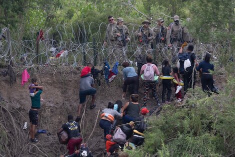 Imigrantes enfrentan a guadrias fronterizos de EE.UU. tras cruzar el Río Grande en Matamoros, México.