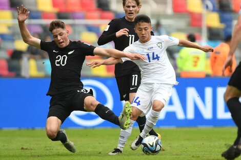 Fayzullaev disputa el balón con Kelly-Heald. Fue 2-2 entre uzbecos y neozelandeses (Fuente: Télam)