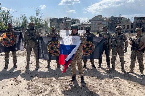 Yevgeny Prigozhin posa en Bajmut con la bandera rusa delante de mercenarios del grupo Wagner. (Fuente: AFP)