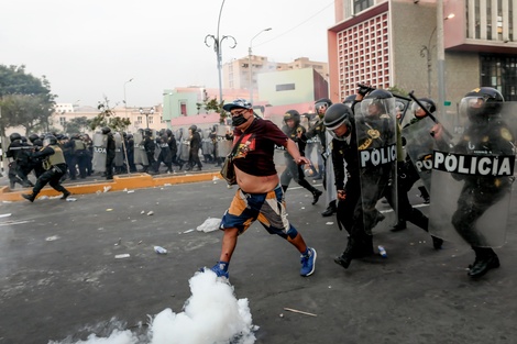 Un manifestante enfrenta a policías durante una protesta en el centro de Lima. 