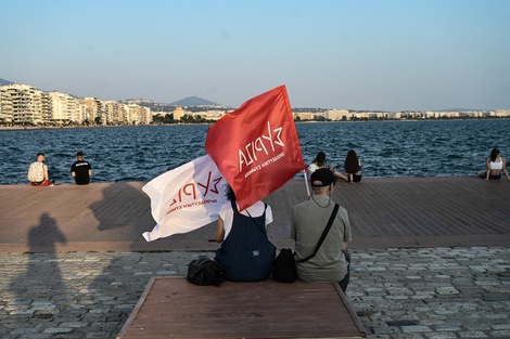 Simpatizantes con banderas del partido izquierdista Syriza miran el mar durante un acto electoral en Tesalónica.