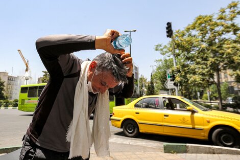 Un hombre se refresca la cabeza en medio a la ola de calor que atraviesa Irán.