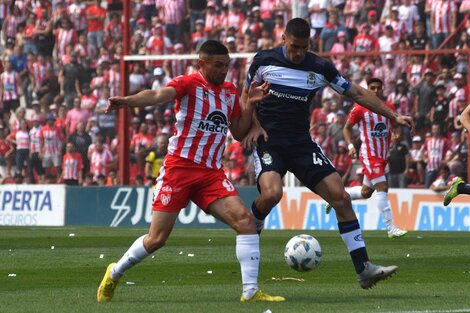 Martínez disputa el balón con Morales, en el empate entre la Gloria y el Lobo (Fuente: Télam)