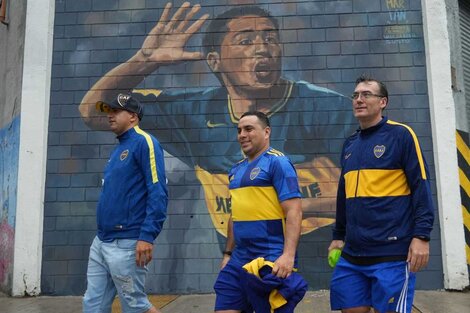 Socios de Boca llegan a votar. De fondo, un mural de Juan Román Riquelme.