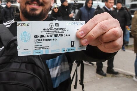 Un hincha exhibe su ticket para ver a la Selección en el Monumental