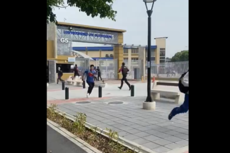 Los estudiantes corren en la puerta de la Universidad de Guayaquil ante el ataque del grupo comando. (Foto: Captura de video)