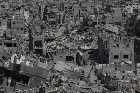 Una bandera palestina flamea en medio de las ruinas en Khan Yunis.