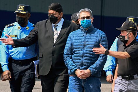 Juan Orlando Hernandez yendo al avión de la DEA para su extradición.