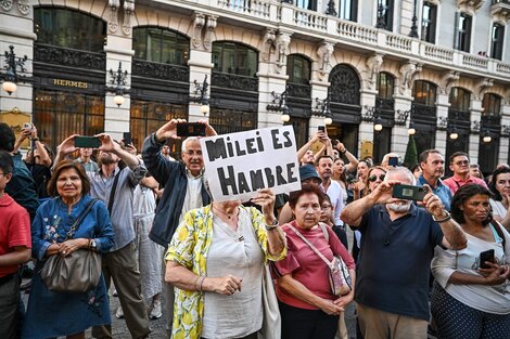 Una mujer sostiene un cartel que cuestiona las políticas de ajuste de Javier Milei.