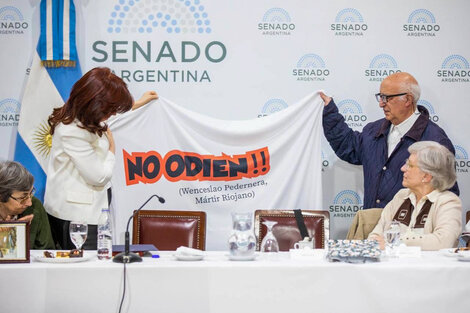 Cristina Kirchner en su primera aparición pública tras el atentado, junto a  curas villeros, de Opción por los Pobres y hermanas laicas y religiosas. La bandera recuerda la frase de Wenceslao Pedernera, dirigente del Movimiento Rural Cristiano y colaborador del obispo Enrique Angelelli, al ser asesinado durante la última dictadura. 