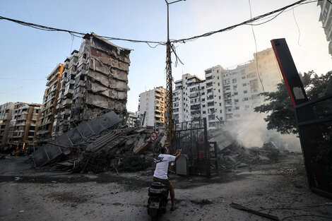 Un hombre fotografía un edificio derrumbado en un suburbio de Beirut.