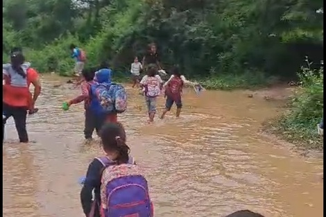 Niños y niñas deben caminar por aguas contaminadas para llegar a su escuela 