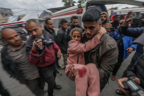 Una niña herida en un ataque a un campo de refugiados en Gaza es llevada a un hospital.