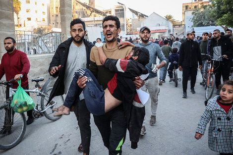 Un hombre alza a un niño herido tras un bombardeo en Ciudad de Gaza.