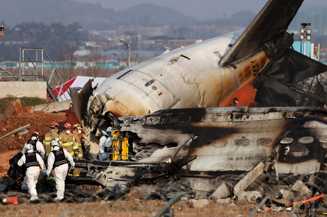 Los bomberos trabajan en los restos del avión Jeju Air en el Aeropuerto Internacional de Muan