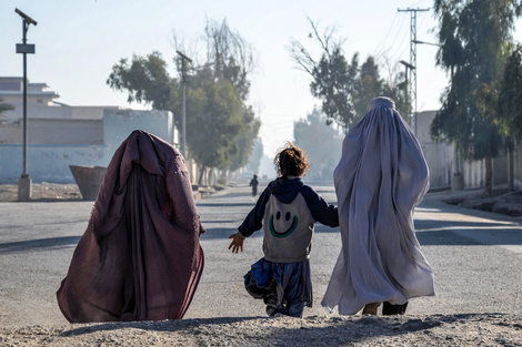 Mujeres afganas vestidas con burka y una niña caminan por una calle en Kandahar